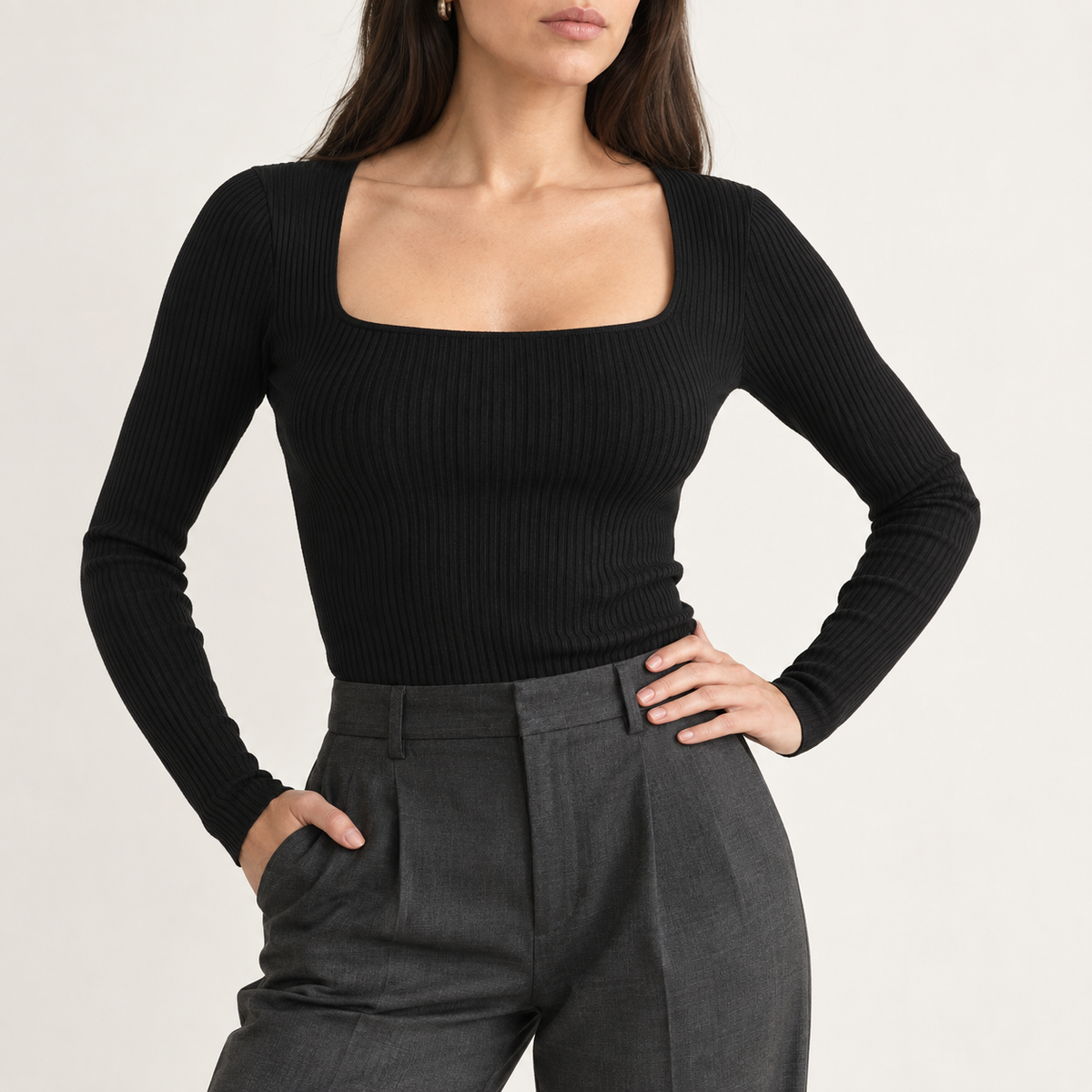 Model wearing the ribbed square-neck top in black with grey pleated trousers