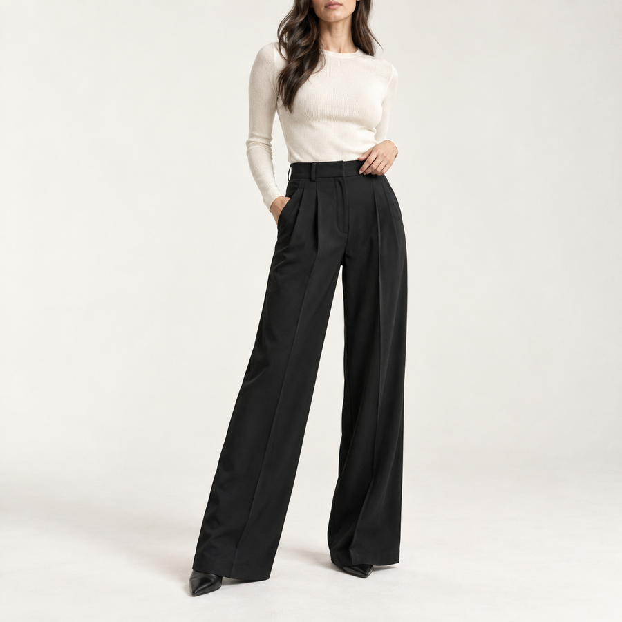Model wearing the pleated wide-leg trousers in black with an ivory knit top