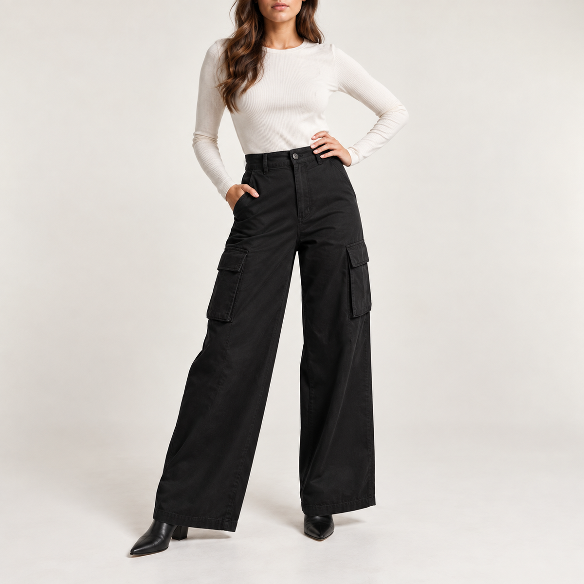 Model wearing the wide-leg cargo trousers in black with an ivory long-sleeve top