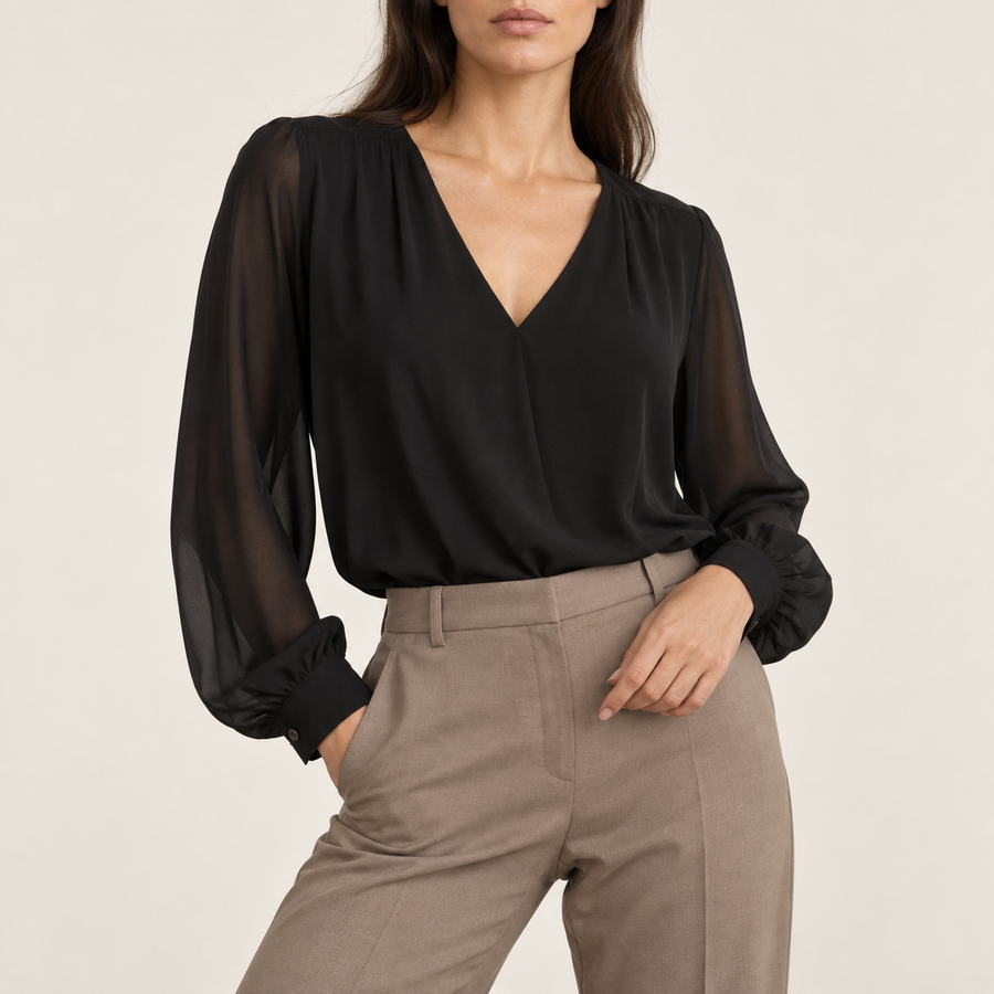 Model wearing the V-neck chiffon blouse in black with taupe tailored trousers